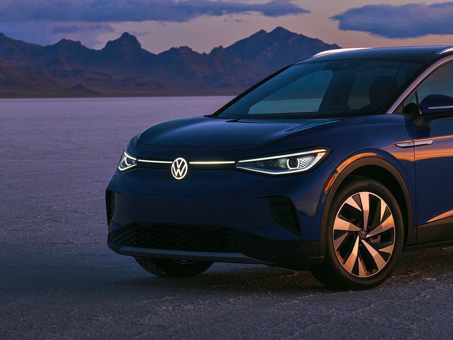 A ¾ front of an ID.4 in Dusk Blue Metallic in a natural sunset setting.