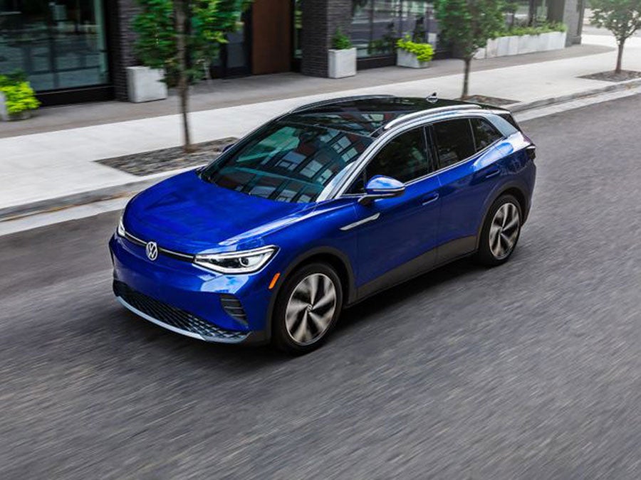 A driver’s side, angled profile shot of an ID.4 in Dusk Blue Metallic parked on an urban street.